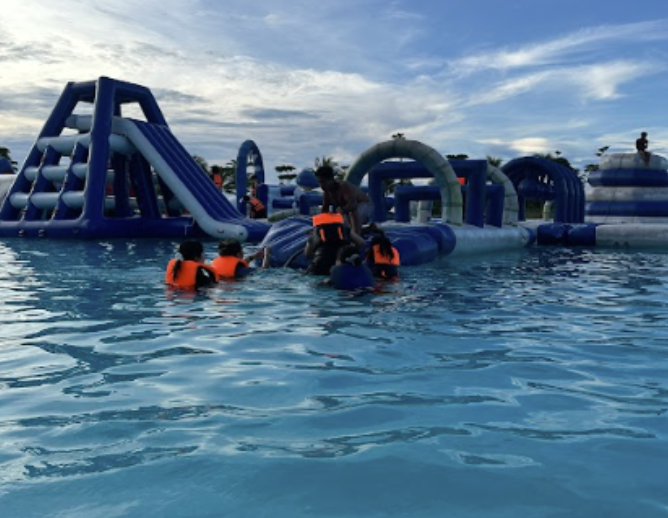Corporate team collaborating on a floating raft challenge in a lagoon, enhancing team bonding Bintan Water Sports Park Fun
