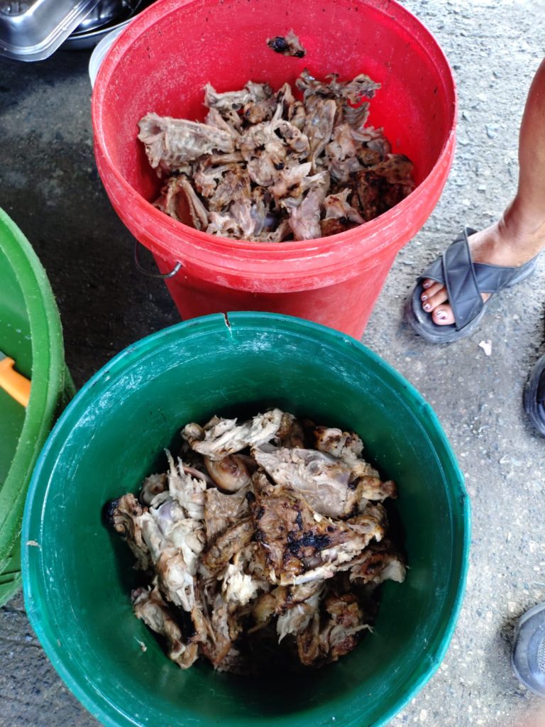 Food scraps in red and green buckets, highlighting waste in impoverished Tondo, Manila, reflecting community struggles for adequate meals.