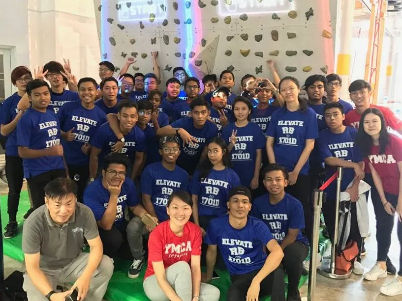 Group of young people in matching blue shirts at a climbing gym